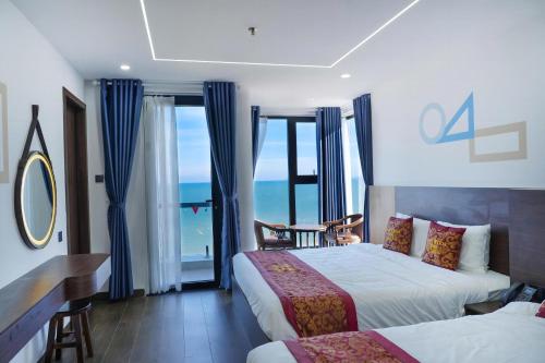 a hotel room with two beds and a view of the ocean at Gia Kiên Hotel in Quy Nhon