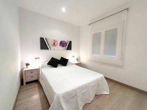 a white bedroom with a white bed and a window at Rhode 1b in Roses