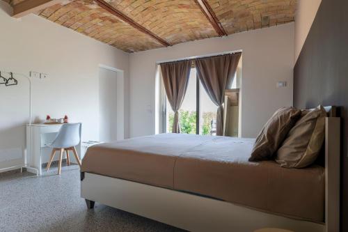 a bedroom with a bed and a table and a window at Lanizoladelroero in Sommariva Perno