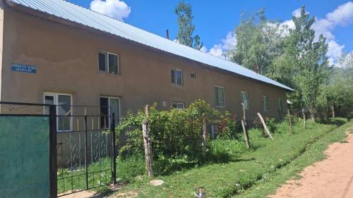 a building with a fence in front of it at Belek Gust house in Toktogul