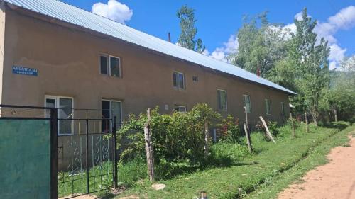 a building with a fence in front of it at Belek Gust house in Toktogul