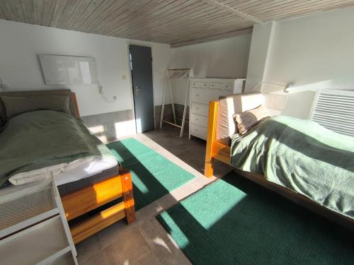 a bedroom with two bunk beds and green carpet at Westerbergen Haus "leucht blick" in Westfehmarn