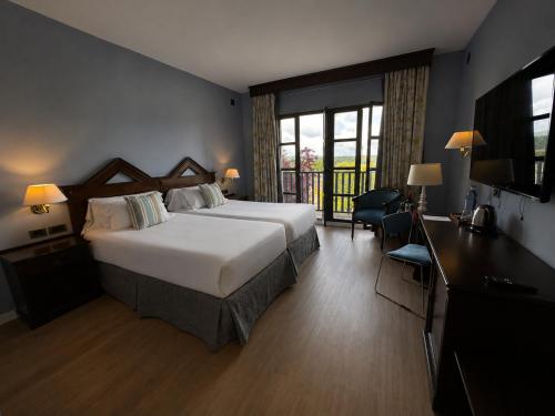 a hotel room with a large bed and a television at RL Ciudad de Úbeda in Úbeda