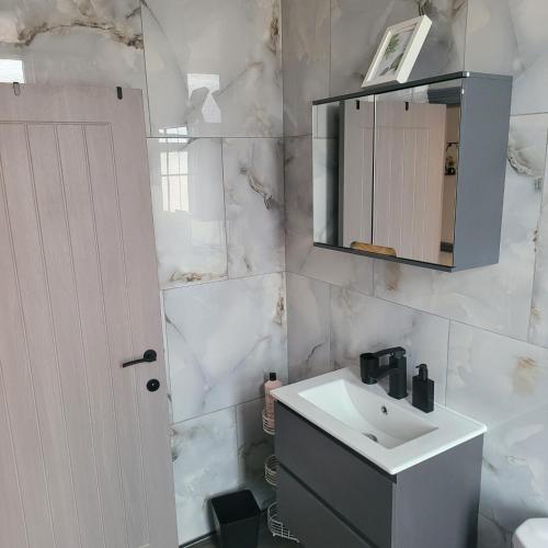 a white bathroom with a sink and a mirror at 6 BR Home Free Parking Sleeps 14 Table Tennis City Centre Pool Table in Central Station