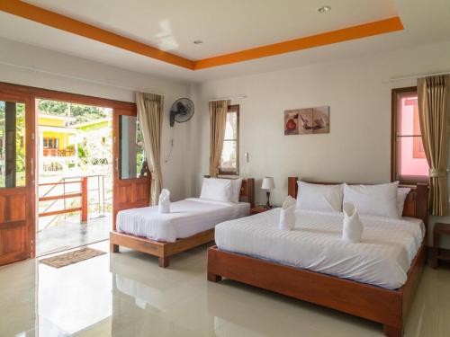a bedroom with two beds and a balcony at Breeze Bay Villa in Wok Tum