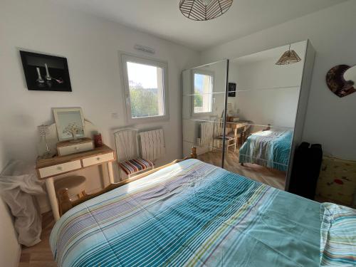 a bedroom with a bed and a mirror at Gîte Ghislaine in Péaule