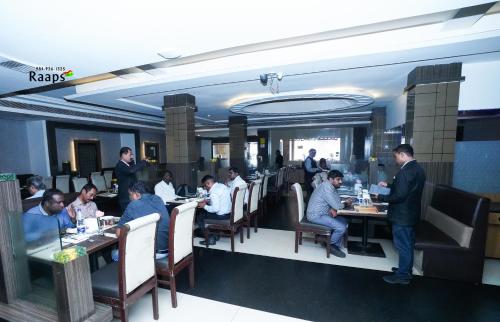 a group of people sitting at tables in a restaurant at Hotel SVM Grand Koti in Hyderabad