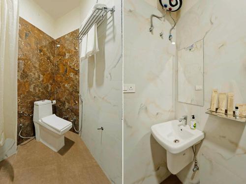 a bathroom with a shower and a toilet and a sink at Anandam Hotel in Jaipur