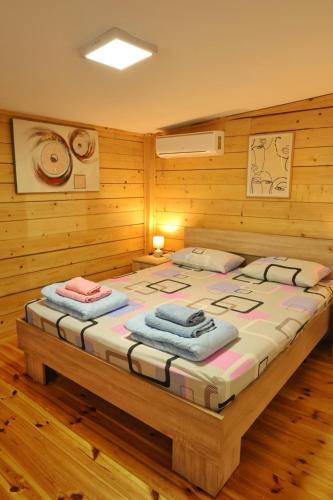 a bedroom with a bed with two towels on it at Kucica Enterprise-Ada Bojana in Ulcinj