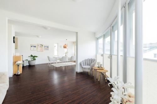 a living room with white walls and a hard wood floor at Helles Penthouse mit Dachterrasse & Bergblick in Mondsee