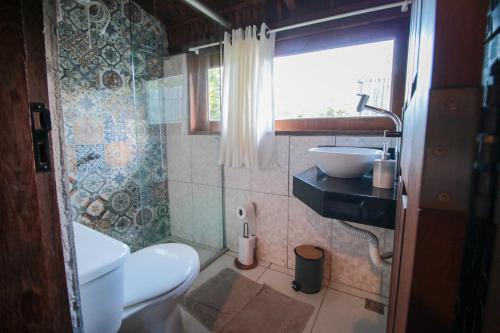 a bathroom with a toilet and a sink and a window at Pousada Cajuzinho do Cerrado in Cavalcante