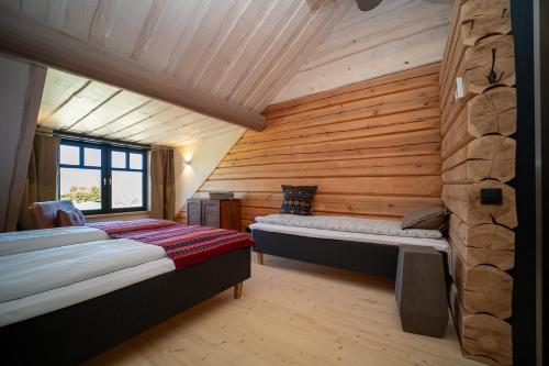 ein Schlafzimmer mit zwei Betten in einer Blockwand in der Unterkunft Ülase Riverside Lodge, Rural Retreat for 20 Guests, Private Smoke Sauna Available, Estonia in Lohu