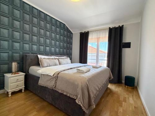 a bedroom with a large bed with a large padded wall at Apartman Emaus in Međugorje