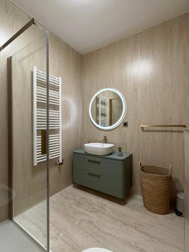 a bathroom with a sink and a mirror at Apartman Emaus in Međugorje