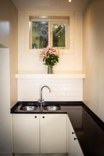 a kitchen with a sink and a vase of flowers at Hidden get away in Lewes in Lewes