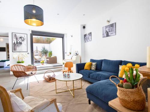 a living room with a blue couch and a table at Grande Maison familiale - Piscine privée & Jardin clos - 10min Avignon & Château-neuf-du-Pape - Climatisation - Parking privé gratuit - Animaux admis in Sorgues