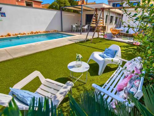 a backyard with chairs and a table and a pool at Grande Maison familiale - Piscine privée & Jardin clos - 10min Avignon & Château-neuf-du-Pape - Climatisation - Parking privé gratuit - Animaux admis in Sorgues