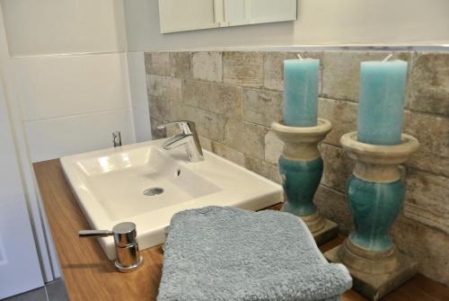 a bathroom with a sink and two blue candles at Haus Kranenborgh im Mühlenspiegel Steinhude am Meer in Steinhude