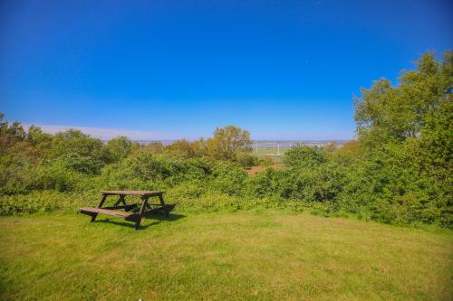 a wooden picnic table sitting in a field at Forest Hills Hotel & Country Club in Frodsham