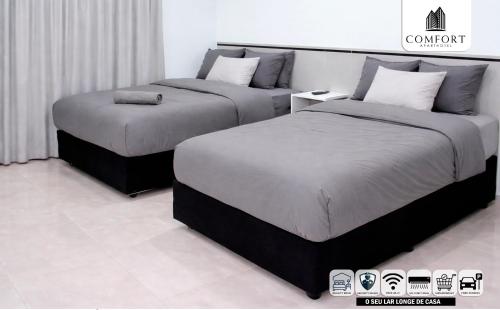 two beds sitting next to each other in a room at Comfort Aparthotel in Chimoio