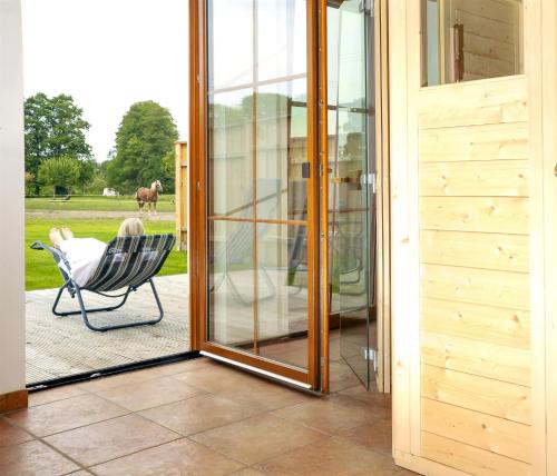 an open sliding glass door with a chair on a patio at Landhaus Brodack in Alt Zauche