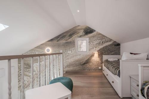 a attic bedroom with a bed and a staircase at Preilos Perliukas in Preila