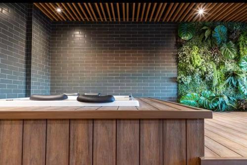 a wellness center with a hot tub and a brick wall at Studio na Av Esmeraldas com garagem in Marília
