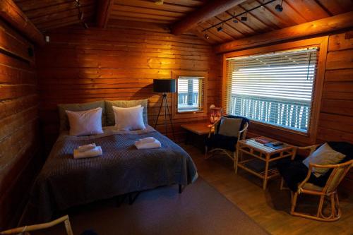 a bedroom with a bed in a wooden cabin at Hotel Krapi in Tuusula