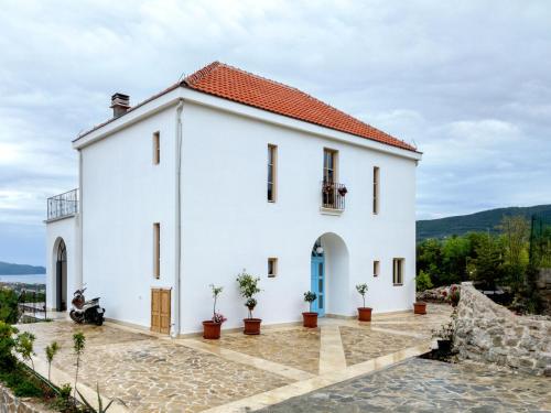 a white house with a red roof at Santa Barbara House in Ratiševina