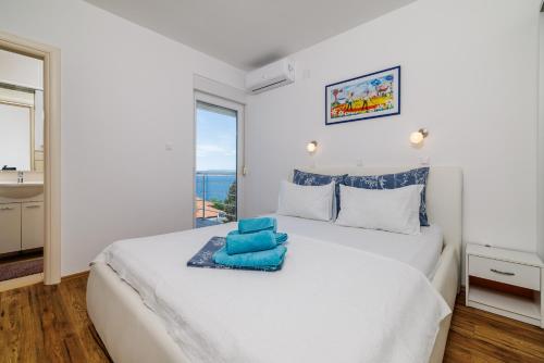 a bedroom with a white bed with blue towels on it at Melanie in Crikvenica