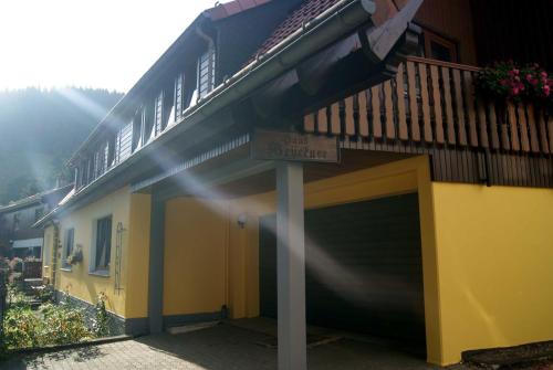 a building with a garage with a sign on it at Pension Haus Brückner in Wildemann