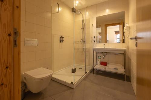 a bathroom with a shower and a toilet and a sink at Casa da Baixa by PURUS in Coimbra