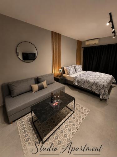 a living room with a couch and a bed at VARTAN LUX apt in Alexandroupoli