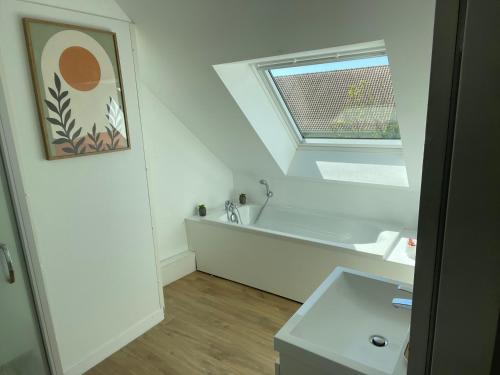 a white bathroom with a sink and a window at Maison de campagne in Le Wast