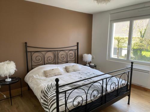 a bedroom with a black bed and a window at Maison de campagne in Le Wast