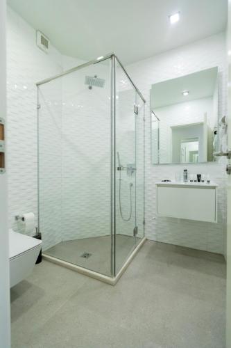 a bathroom with a glass shower and a sink at Hotel Bologna in Vlorë
