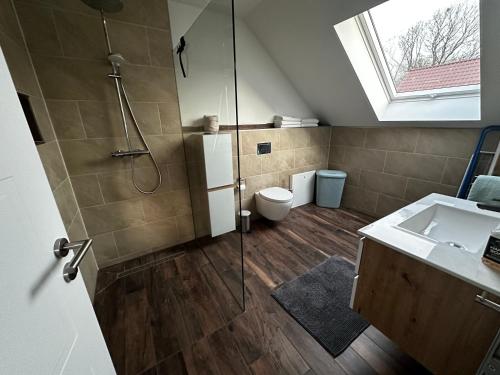 a bathroom with a shower and a toilet and a sink at Ferienhaus Kronseeliebe in Lychen