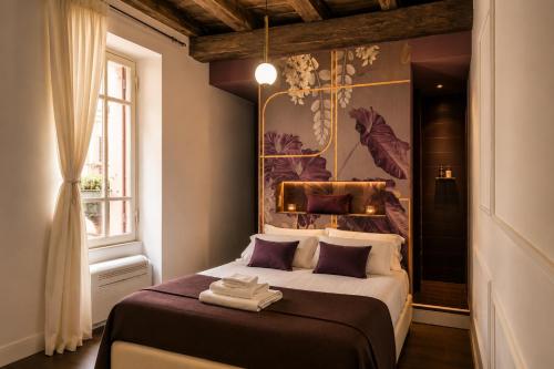 a bedroom with a bed and a painting on the wall at Vicolo delle Belle Suite in Terracina