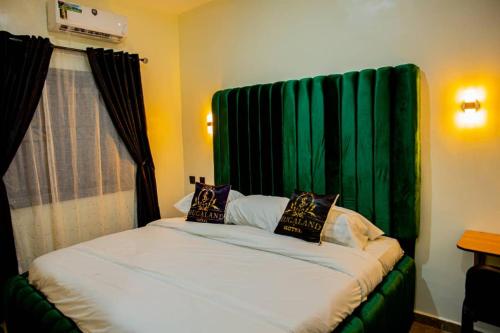 a room with a bed with a green curtain at Shugaland hotel and lounge in Ibadan