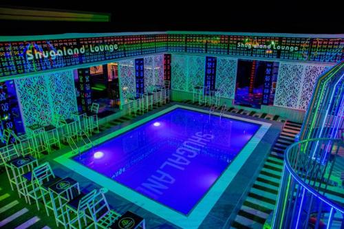 a swimming pool with tables and chairs and lights at Shugaland hotel and lounge in Ibadan