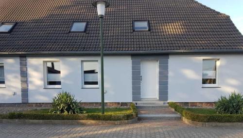 a white house with a black roof at Pribbenower Ferienhaus in Pribbenow