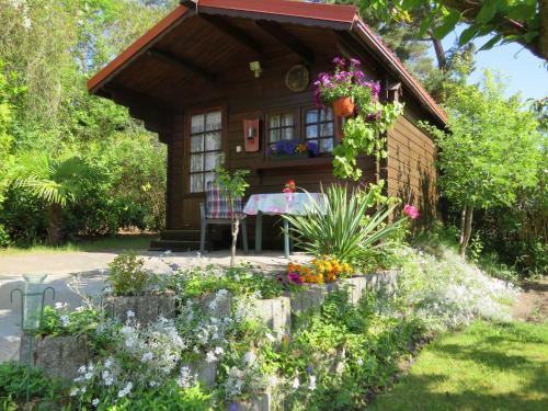 a cottage with a table and flowers in front of it at Kölp - Block`s Ferienhäuschen in Kolpinsee