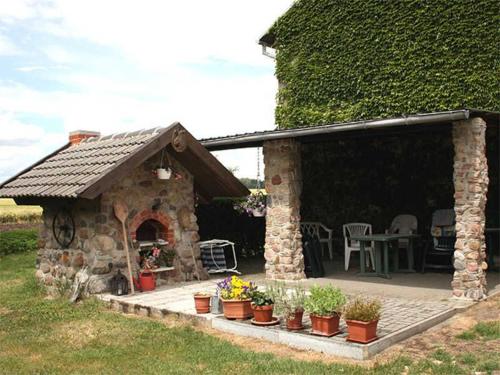 a stone house with a patio with plants in front of it at Ferienwohnungen auf dem Lande in Kittendorf