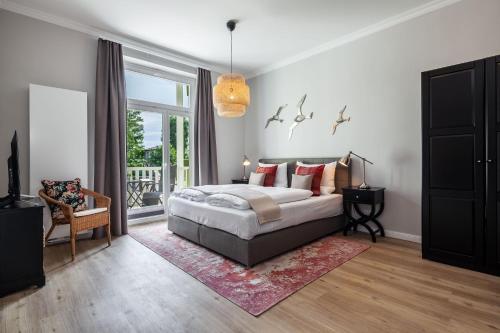 a bedroom with a bed and a large window at App Osiria in Kühlungsborn