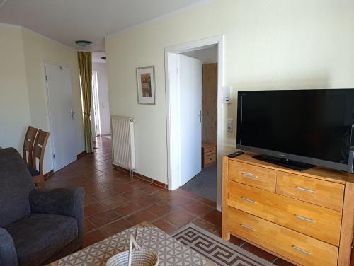 a living room with a flat screen tv on a wooden dresser at Hermannstr 14-Whg 10 in Kühlungsborn