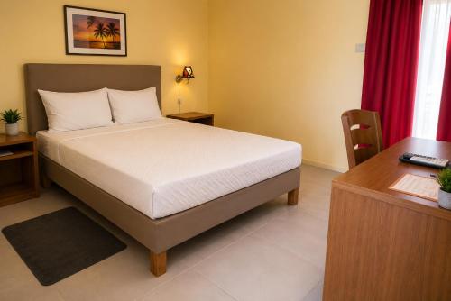 a bed in a room with a desk and a bed sidx sidx sidx at Viana Hotel in Luanda