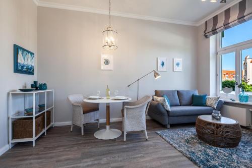 a living room with a table and a couch at App Flamingo in Kühlungsborn