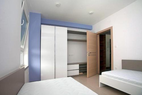 a room with a bedroom with a bed and a closet at Apartmani Daška II in Njivice
