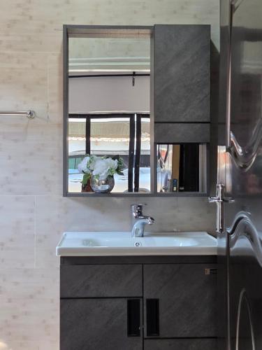 a bathroom with a sink and a mirror at Mel's Apartment in Ndola