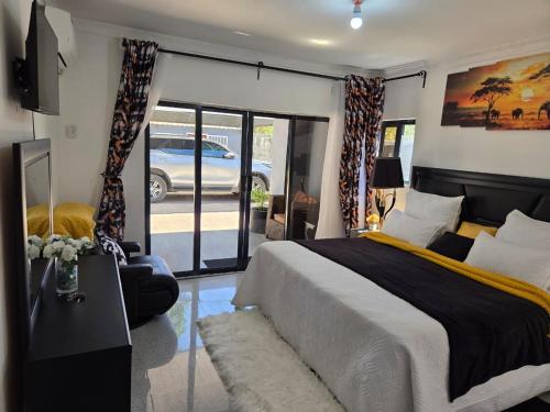 a bedroom with a bed and a sliding glass door at Mel's Apartment in Ndola